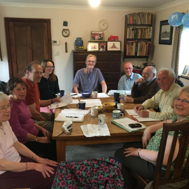 a smiling group of 9 Torridge Green Party members sit around a table